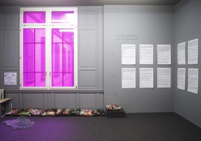 L’espace du Studiolo avec une fenêtre rose et un test de personalité au mur.